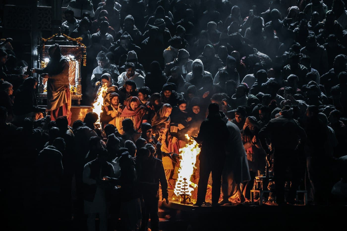 Guests gathered around ceremonial fire light during an evening riverside ceremony