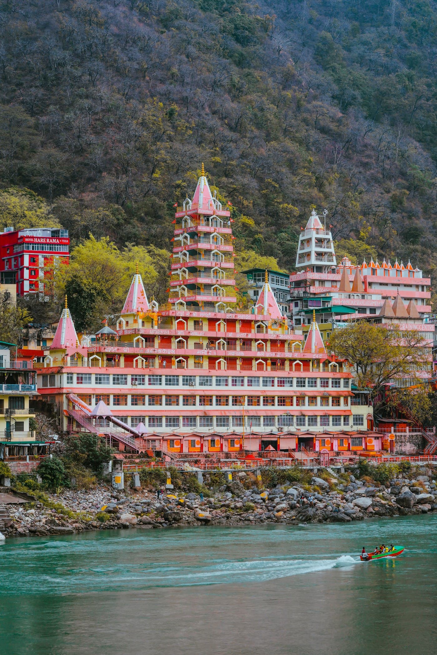 Boat traveling the Ganges beside temple architecture