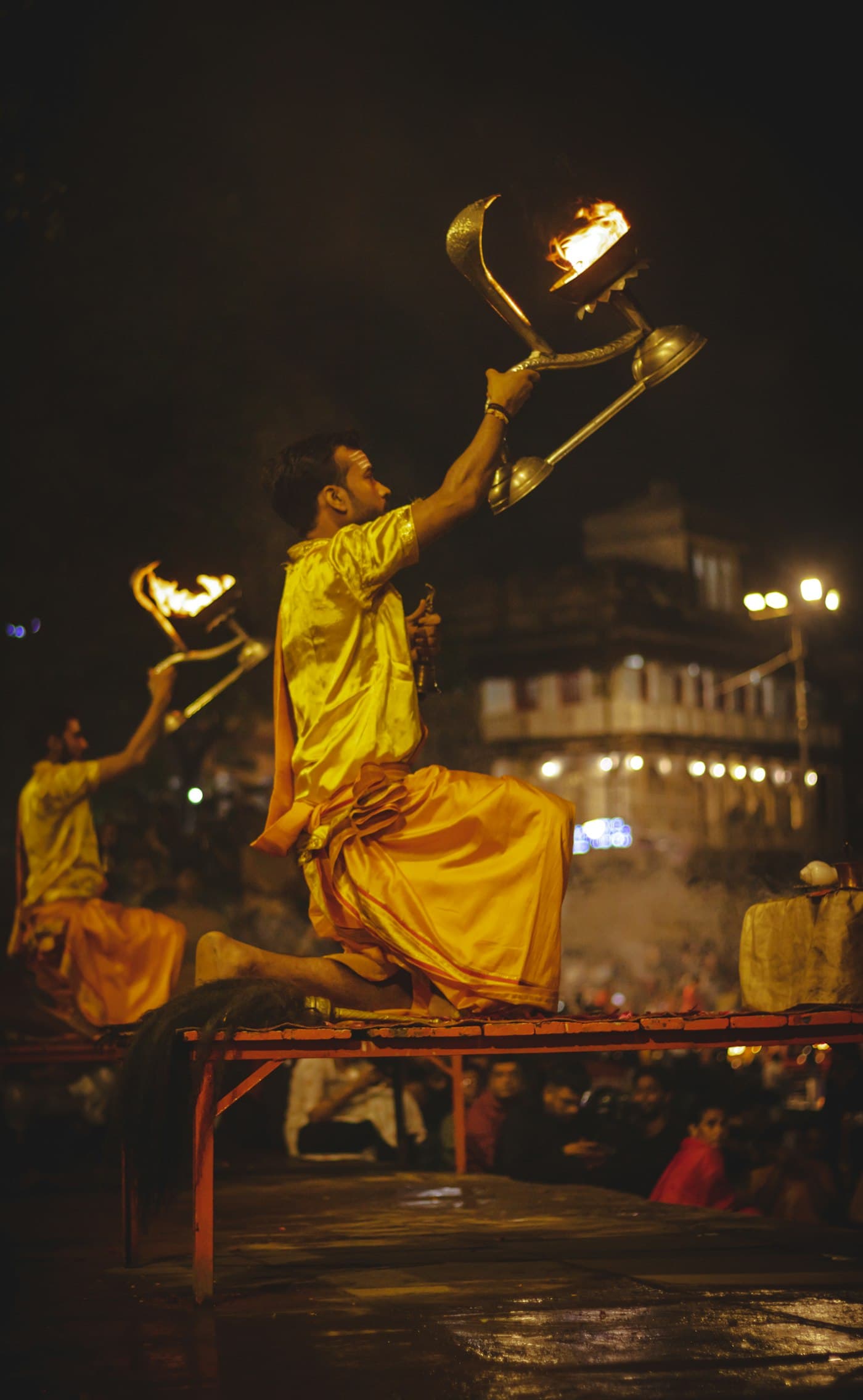 Priest lifting a ritual lamp high during aarti