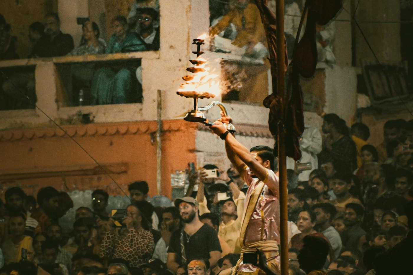 Crowd gathered around a devotee with a lit lamp at Dashashwamedh