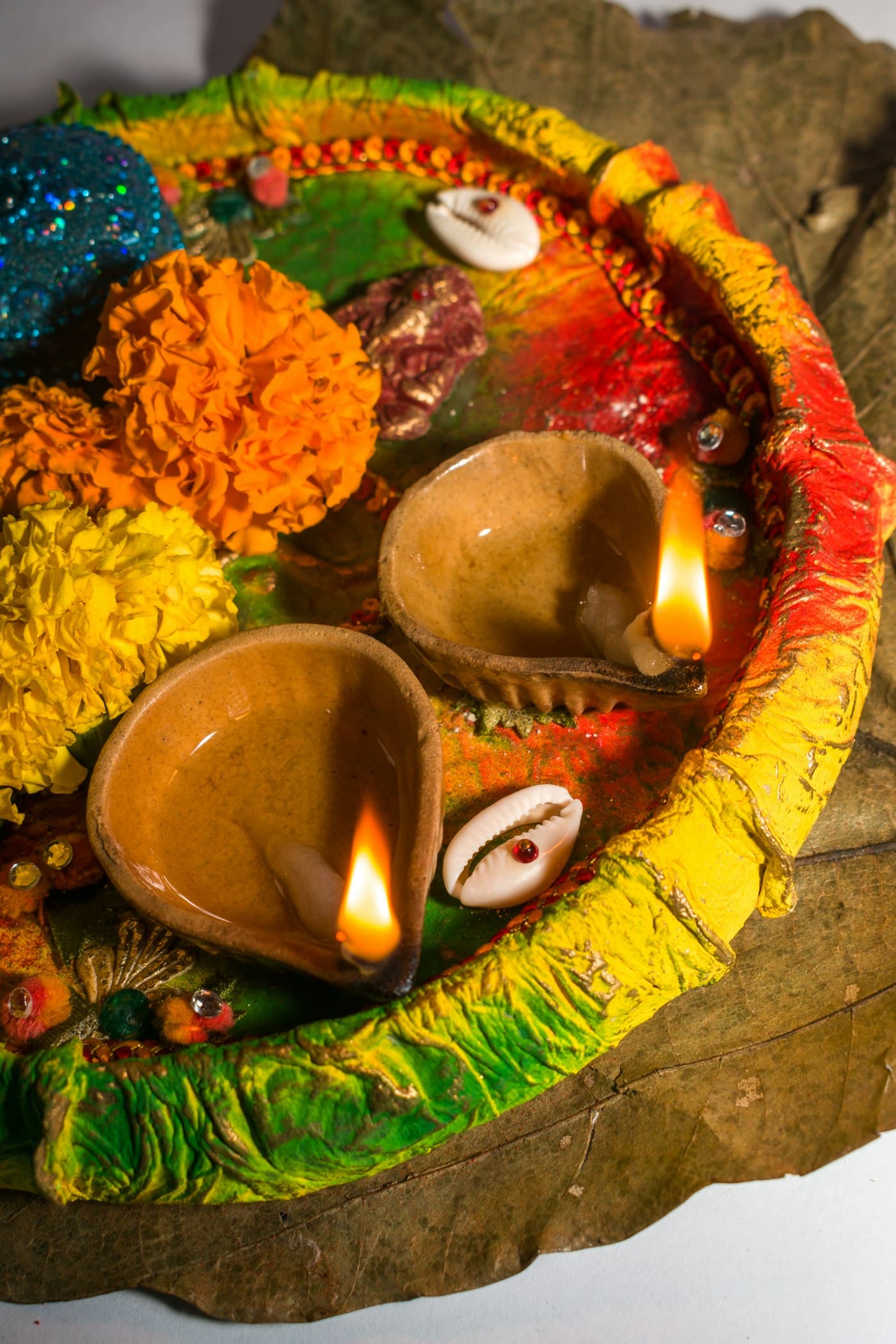 Burning diya surrounded by colorful flower petals