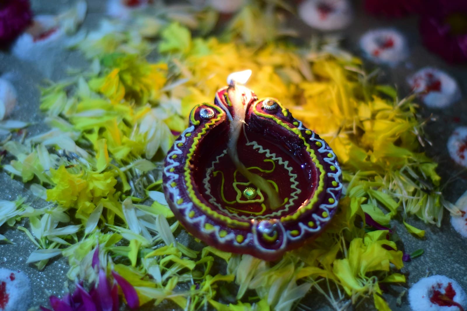 A glowing ceremonial diya surrounded by marigold petals for an intimate family aarti
