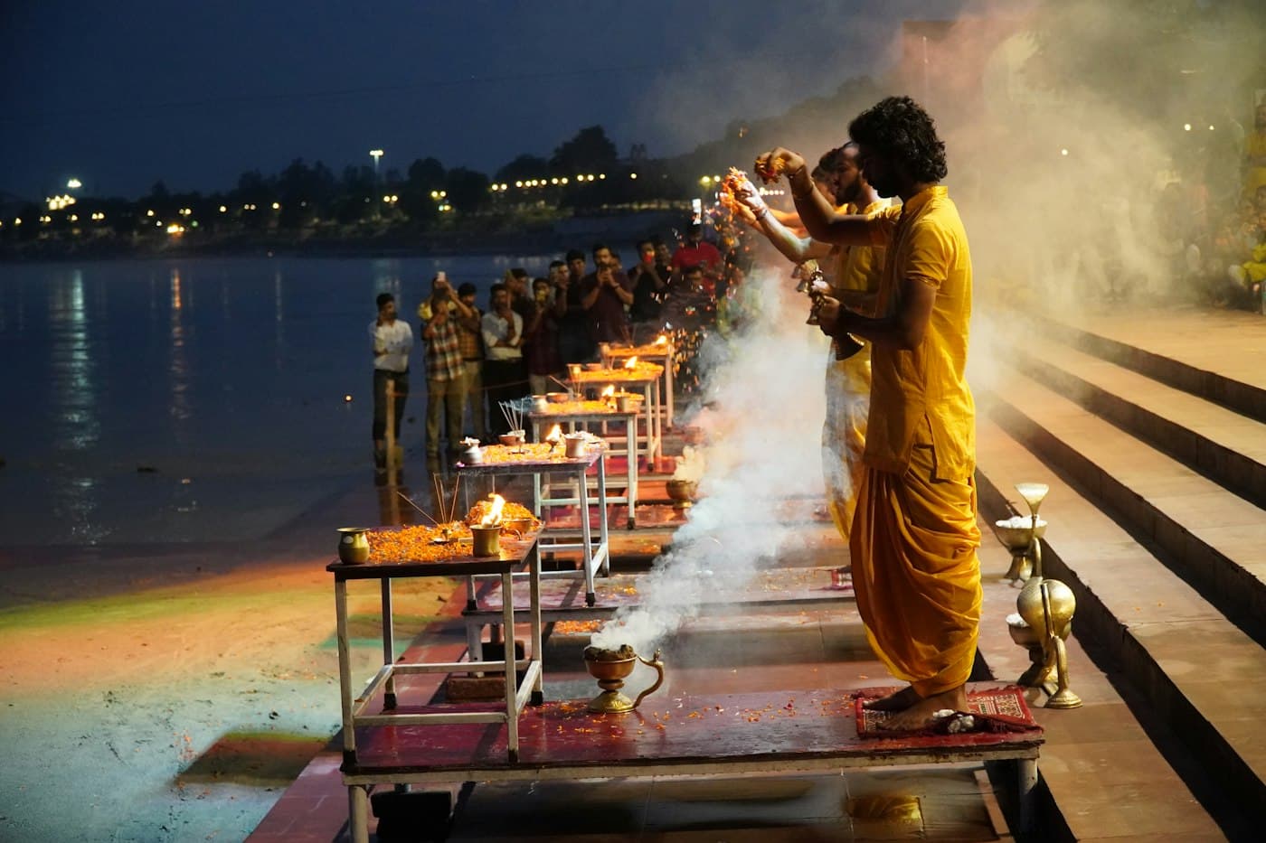 Devotees gathered around ceremonial fire during riverside aarti